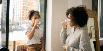 A black woman and black child drinking water